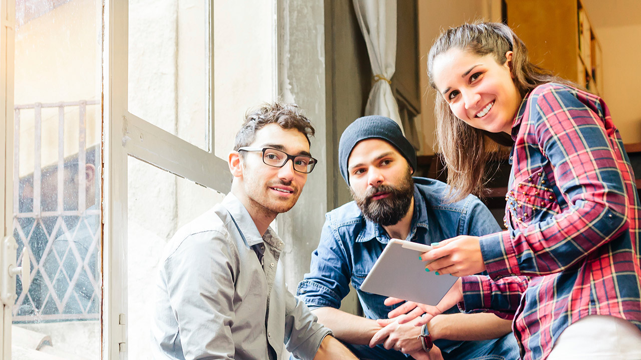 GettyImages-Fotograf-Tommaso-Tagliaferri-BrandIgnite-Three-friends-with-tablet-on-staircase-looking-at-camera-1280x720